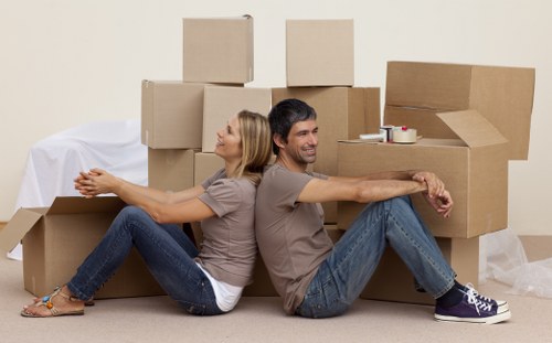 Professional movers carrying furniture near a house in Chingford