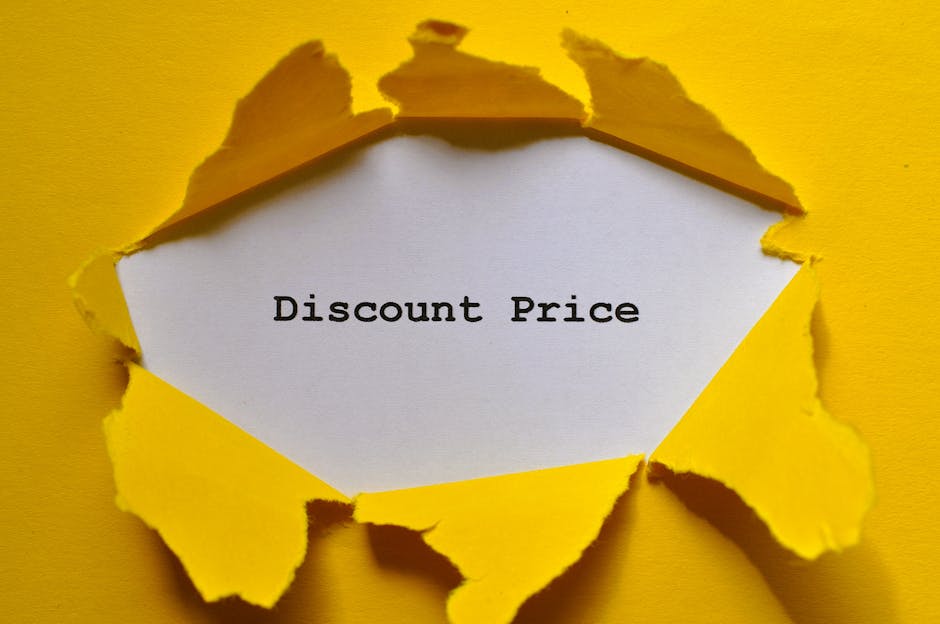 A close-up image showing a yellow paper surface with a torn edge revealing a white paper underneath. The white paper displays the message 'Discount Price' typed in black text. The torn yellow paper creates a jagged, irregular opening, suggesting a revealing or uncovering of the discount offer, which could be related to furniture, packaging, or promotional materials associated with house removals or moving services. The scene is well-lit, with the torn edges displaying shadows that add depth to the image. This visual could be used in the context of customer incentives or special offers from [COMPANY_NAME] for home relocation and furniture transport services, subtly supporting content about packing, moving, and delivery logistics.